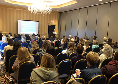 attendees focus on the projector screen during one of the many breakout sessions