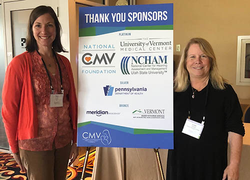 conference committee members show off poster of sponsors